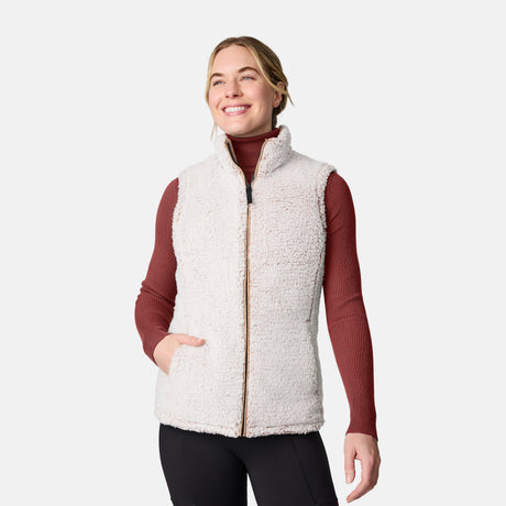 [CJ is 5'10" wearing size S.] Women’s Free Country beige diamond-quilted vest with zippered pockets and high collar—reverses to cozy sherpa for added warmth and texture. Layered over a green ribbed sweater and black pants for a stylish, cold-weather look.