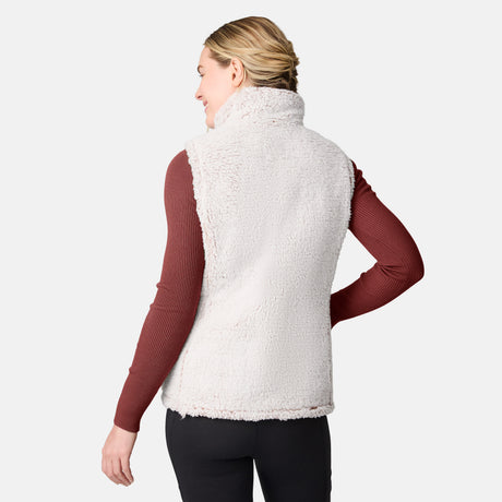 [CJ is 5'10" wearing size S.] Women’s Free Country beige diamond-quilted vest with zippered pockets and high collar—reverses to cozy sherpa for added warmth and texture. Layered over a green ribbed sweater and black pants for a stylish, cold-weather look.