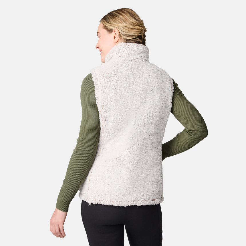 [CJ is 5'10" wearing size S.] Women’s Free Country beige diamond-quilted vest with zippered pockets and high collar—reverses to cozy sherpa for added warmth and texture. Layered over a green ribbed sweater and black pants for a stylish, cold-weather look.