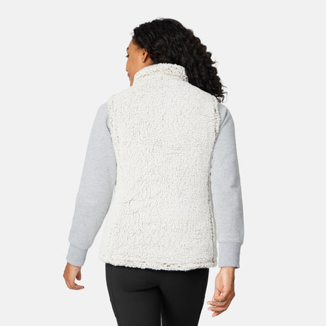 [Angelique is 5'10" wearing size S.] Women’s Free Country light green quilted vest with diamond pattern and black zippered pockets—reverses to cozy sherpa for added warmth and texture. Styled over a gray long-sleeve shirt and blue pants for a relaxed, transitional-weather look.