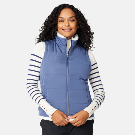[Angelique is 5'10" wearing size S.] Woman wearing a blue puffer vest over a striped shirt on a white background
