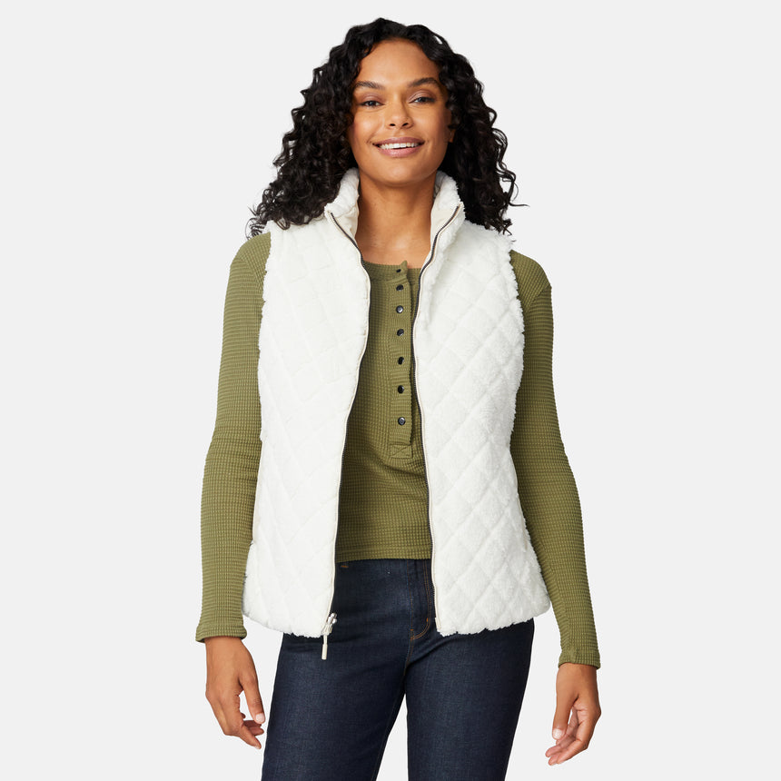 [Angelique is 5'10" wearing size S.] Woman wearing a white quilted vest over a green sweater on a white background