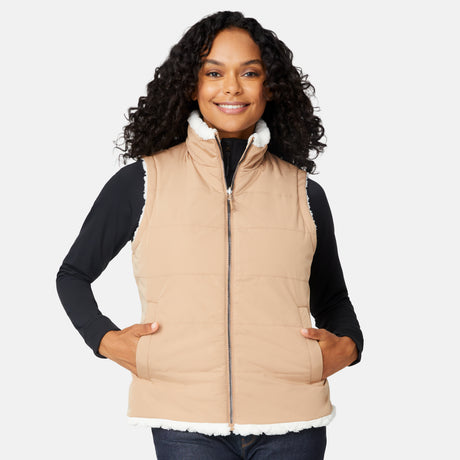 [Angelique is 5'10" wearing size S.] Woman wearing a beige puffer vest with white fur trim on a white background