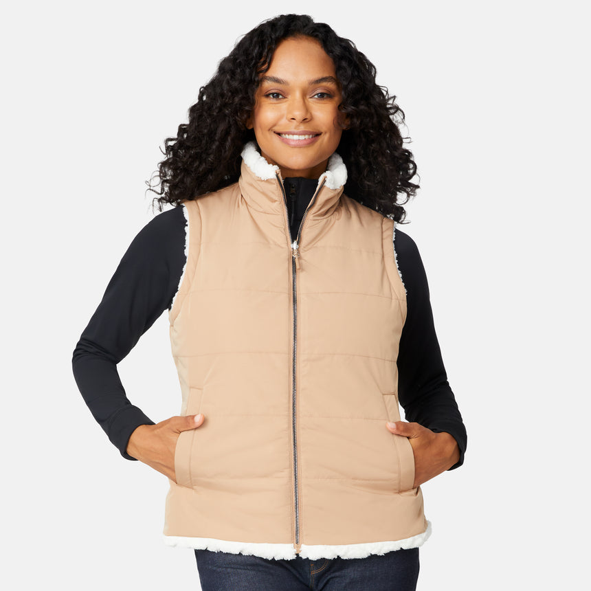 [Angelique is 5'10" wearing size S.] Woman wearing a beige puffer vest with white fur trim on a white background