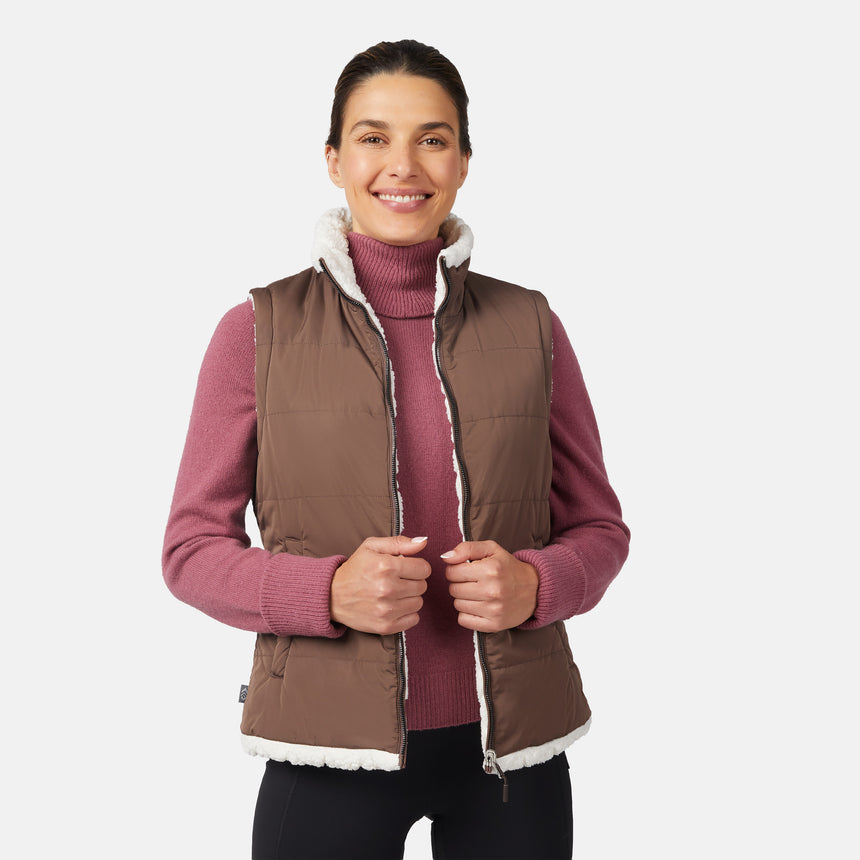 [Olga is 5'9" wearing size S.] Woman wearing a brown vest over a pink sweater on a white background