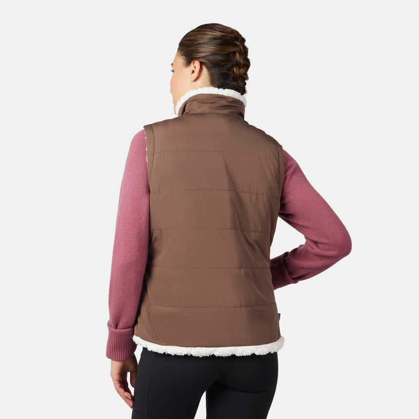 [Olga is 5'9" wearing size S.] Woman wearing a brown vest over a pink shirt on a white background