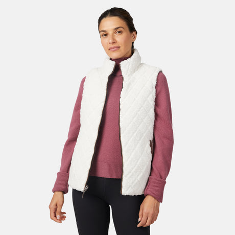 [Olga is 5'9" wearing size S.] Woman wearing a white quilted vest over a pink sweater on a white background