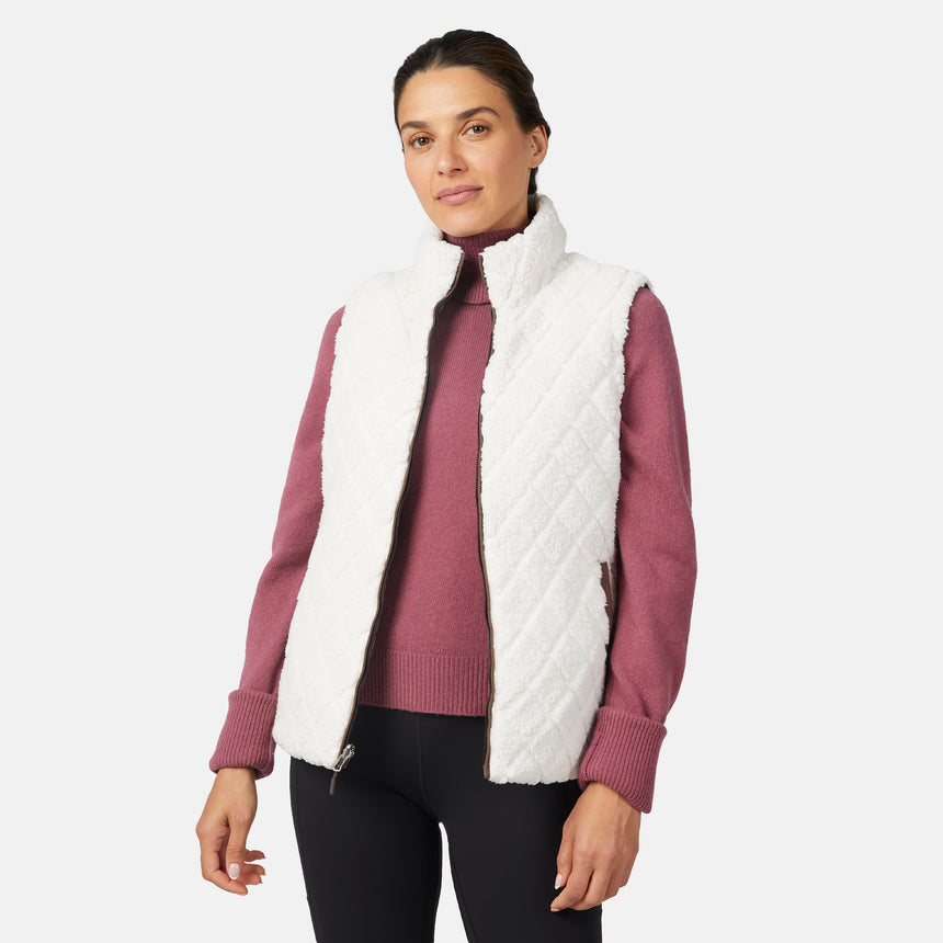 [Olga is 5'9" wearing size S.] Woman wearing a white quilted vest over a pink sweater on a white background
