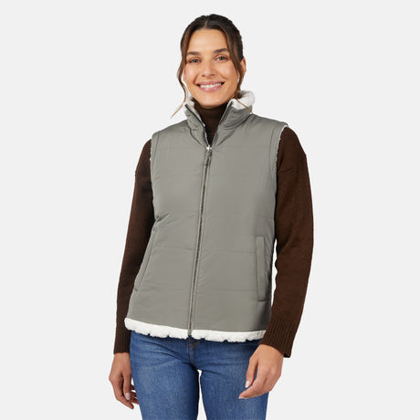 [Olga is 5'9" wearing size S.] Woman wearing a green puffer vest over a brown shirt on a white background