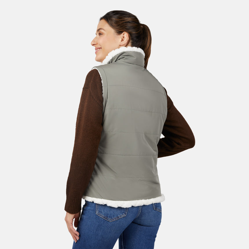 [Olga is 5'9" wearing size S.] Woman wearing a green puffer vest over a brown sweater on a white background