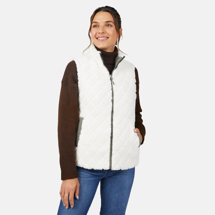 [Olga is 5'9" wearing size S.] Woman wearing a white fur vest over a brown long-sleeve shirt on a white background