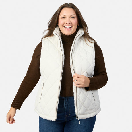 Smiling plus size woman wearing a white quilted Stratus Lite II reversible vest over a brown knit sweater.