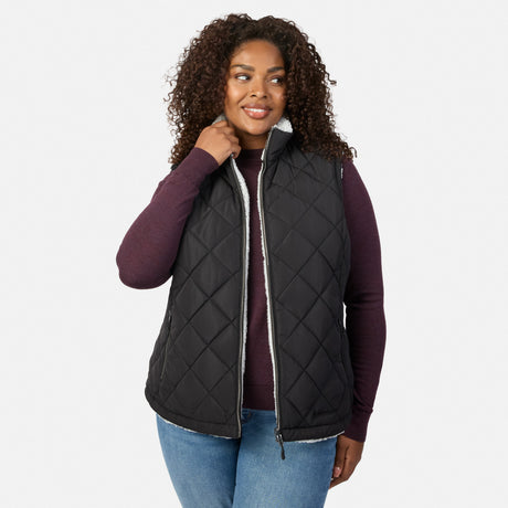 Plus size woman wearing black quilted vest with white fleece lining and zip closure over burgundy knit top.