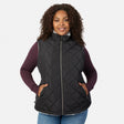 Plus size woman wearing a black quilted Stratus Lite II reversible vest with white fleece lining and burgundy sleeves peeking out