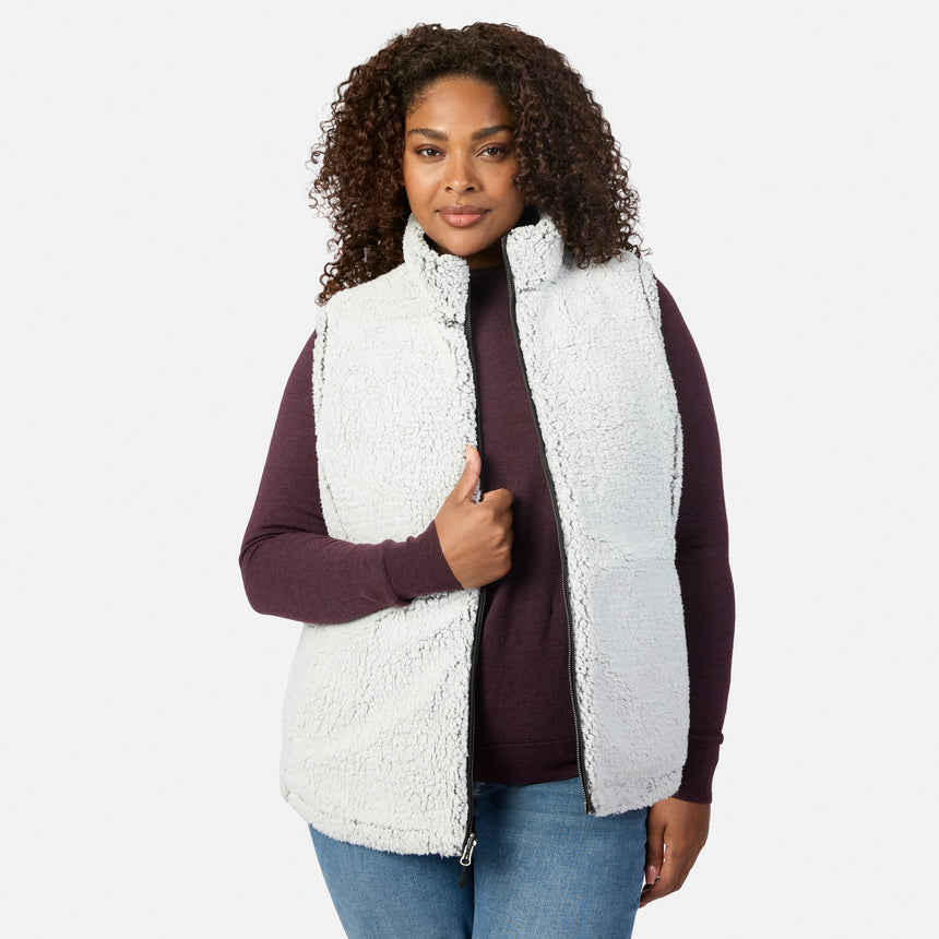Plus size woman wearing the white sherpa reverse of the Stratus Lite II vest with burgundy sleeves visible