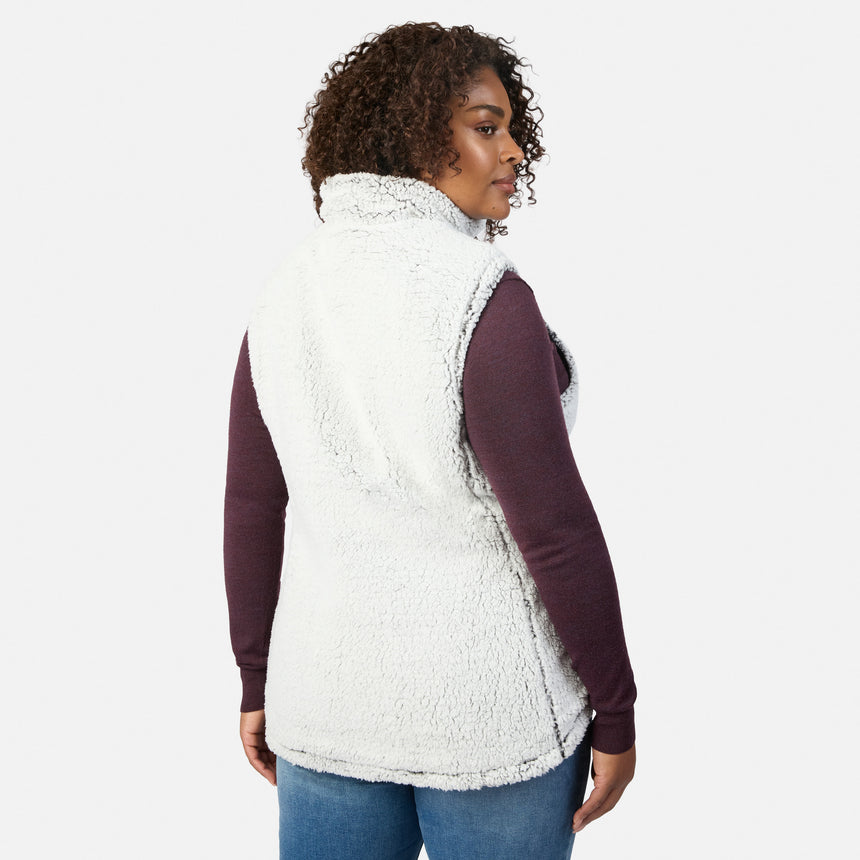 Side view of a woman wearing the Stratus Lite II reversible vest in white sherpa over a burgundy long sleeve top
