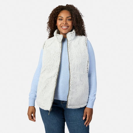 Plus-size woman wearing white sherpa Stratus Lite II reversible vest over a light blue top