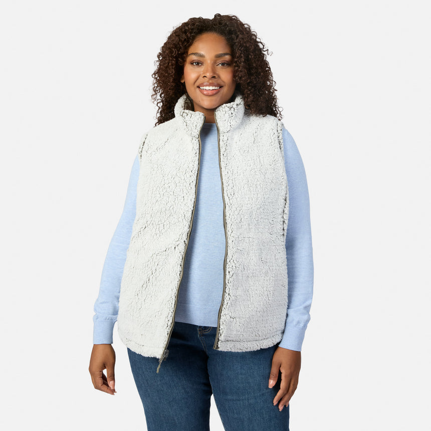 Plus-size woman wearing white sherpa Stratus Lite II reversible vest over a light blue top