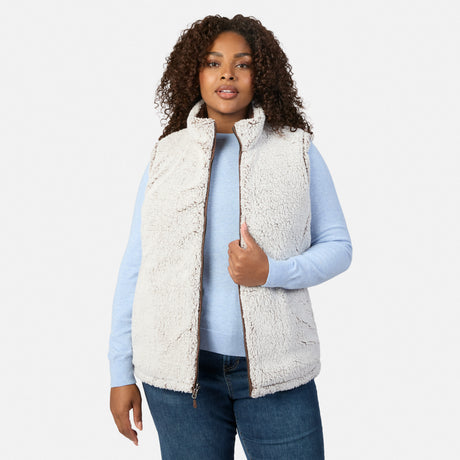 Woman wearing cream sherpa fleece zip vest with high collar over a light blue top