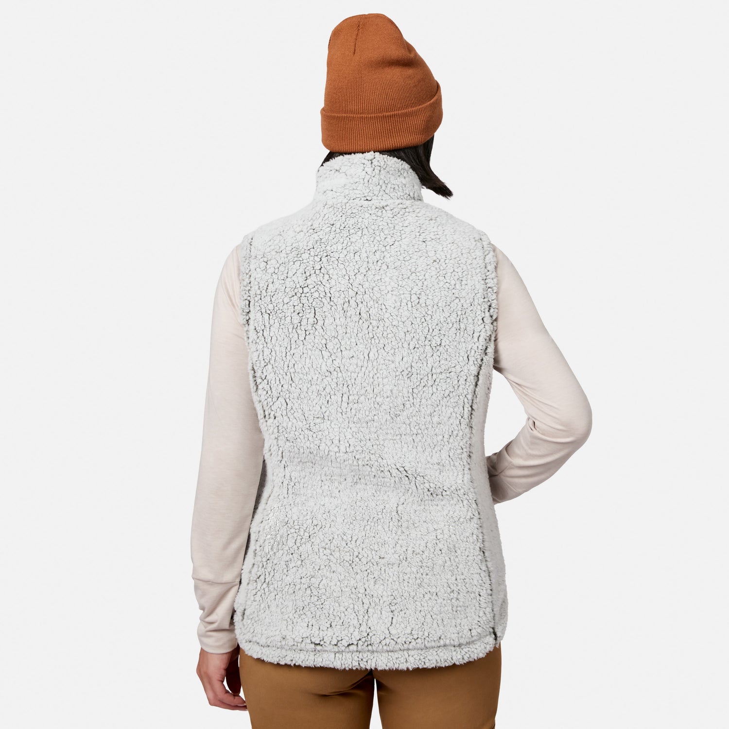 A person, shown from the back against a plain white background, is wearing a brown beanie, a light long-sleeve shirt, and the Free Country Women’s Stratus Lite II Reversible Vest—a fuzzy light gray vest crafted from recycled polyester for lightweight warmth.