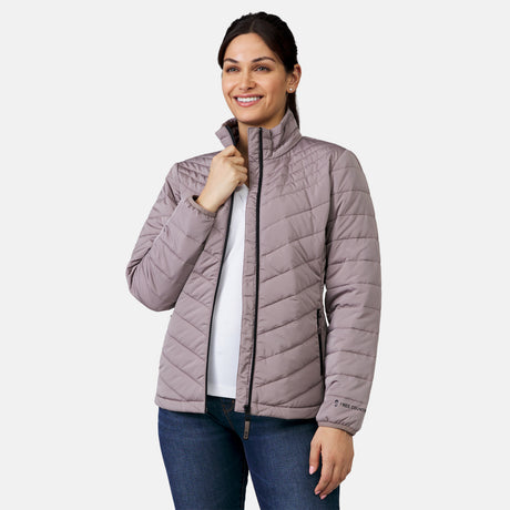 A woman smiles against a light gray background, wearing the Clearance Women's Stow & Go Packable Jacket in light purple over a white shirt and blue jeans.