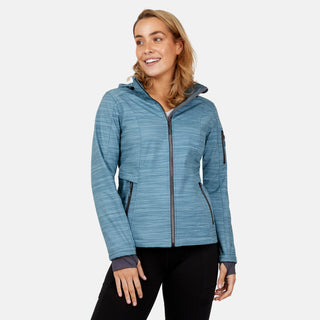 A smiling woman wears the Free Country Women's Aeris II Super Softshell® Jacket, featuring four-way stretch and pockets, paired with black pants against a plain light background.