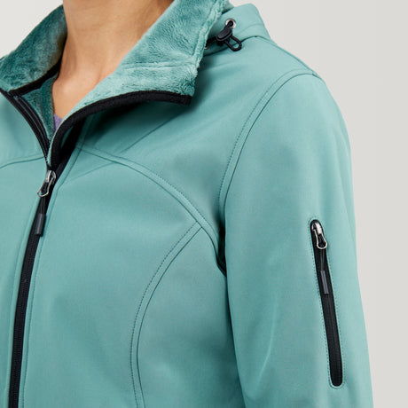 A close-up of a person wearing the Clearance Women's FreeCycle® Super Softshell® Jacket in teal, featuring four-way stretch, a black zipper, zippered sleeve pocket, soft green fleece-lined high collar, and an adjustable hood cord.