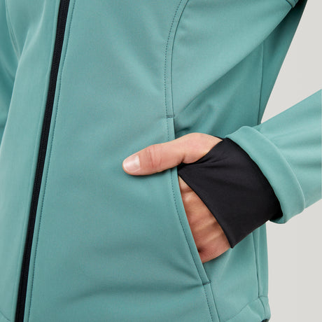 A close-up of a person wearing the Clearance Women's FreeCycle® Super Softshell® Jacket in teal, with their right hand in the pocket. The water-resistant jacket has black inner cuffs with thumbholes for added comfort and protection.