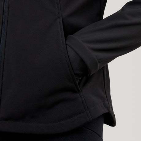 Close-up of a person wearing the Clearance Women's FreeCycle® Super Softshell® Jacket, featuring four-way stretch fabric and a highlighted sleeve, with their right hand in the front pocket against a plain light background.