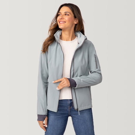 [Olga is 5’9” wearing a size Small.] Woman wearing Free Country Women's Aeris II Super Softshell® Jacket in light blue with a full front zipper opening, soft lining, detachable hood, and water resistant and wind resistant stretch performance fabric, light grey background. Perfect women’s  jacket for fall weather.