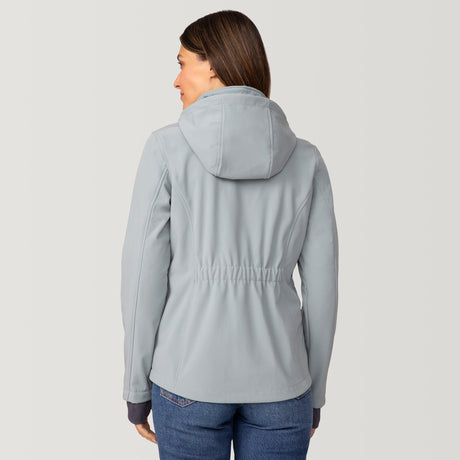 [Olga is 5’9” wearing a size Small.] Woman wearing Free Country Women's Aeris II Super Softshell® Jacket in light blue with a full front zipper opening, soft lining, detachable hood, and water resistant and wind resistant stretch performance fabric, light grey background. Perfect women’s  jacket for fall weather.