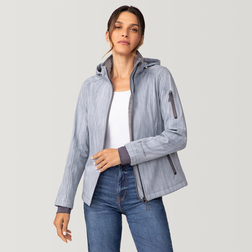 Woman wearing a light gray Women’s Aeris II Super Softshell® Jacket with a zipper closure and zippered pockets, over a white top and blue jeans.