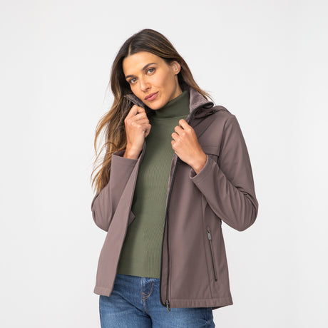 [Olga is 5’9" wearing a size Small.] Woman wearing Free Country Women's TrailTrek Super Softshell® Jacket in brown with a full front zipper opening, lower pockets, soft lining, a hood with an adjustable drawcord, and water resistant and wind resistant stretch performance fabric, light grey background. Best women’s jacket for winter weather.