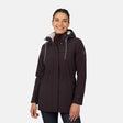 [Jessica is 5'9.5" wearing size S.] Women’s dark-brown hooded softshell jacket with zip-front closure, flap chest pockets, and adjustable drawstrings—features a sleeve patch and is paired with dark pants for a rugged, outdoor-ready look.