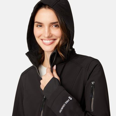 [Jessica is 5'9.5" wearing size S.] Woman wearing Free Country Women's Aeris II Super Softshell® Jacket in black with a full front zipper opening, soft lining, detachable hood, and water resistant and wind resistant stretch performance fabric, light grey background. Perfect women’s  jacket for fall weather.