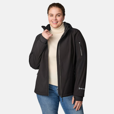 [Karissa is 5'9.5" wearing size 1X.] Woman wearing Free Country black hooded softshell jacket with sleeve zip pocket; worn over blue jeans, shown with raised arms to display fit and structure.