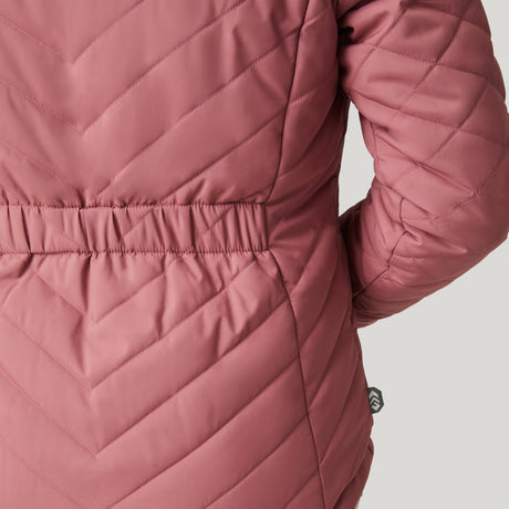 Close-up of the back of the Clearance Women's FreeCycle® Cloud Lite II Reversible Jacket in mauve, featuring diagonal quilting, an elastic waistband, and a small black tag near the side seam. The wearer’s arm is bent.