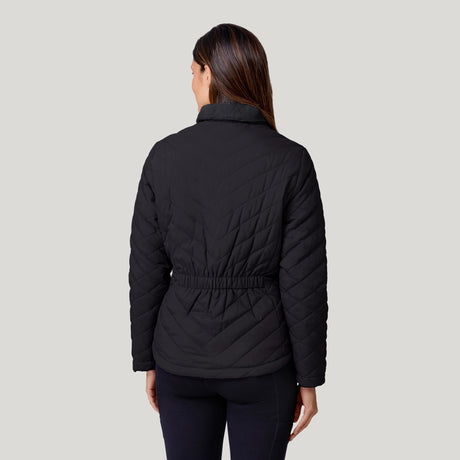 A woman faces away, wearing the Clearance Women's FreeCycle® Cloud Lite II Reversible Jacket in black with an elastic waist and dark pants, set against a plain light gray background.