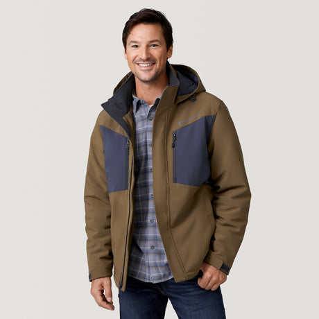 A smiling man wears the Clearance Men's Thermo Softshell® Mid Weight Jacket, styled over a blue plaid shirt and dark jeans, standing against a plain light background.