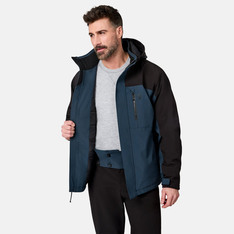[Model is wearing size M.] A man wearing a dark blue and black technical outdoor jacket over a light gray t-shirt and black pants, standing against a light gray studio background.