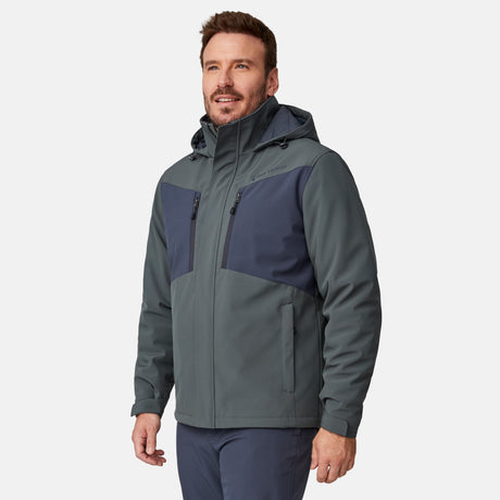 [Joe is 6'0" wearing size M.] Men’s Free Country two-tone hooded zip-front jacket with dark gray body and black paneling across shoulders and chest—features dual vertical zippered chest pockets, side hand pockets, full-length front zipper, and an attached interior snow skirt for enhanced protection against the elements. Paired with matching gray pants for a sleek, coordinated winter look.