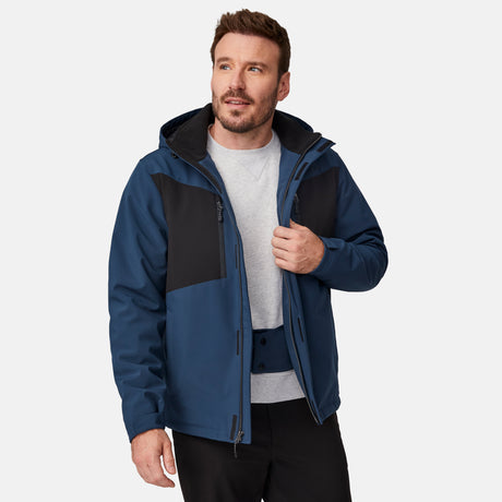 [Joe is 6'0" wearing size M.]  "Men’s Free Country hooded zip-front jacket with black chest panels and deep blue sleeves and body—features dual vertical zippered chest pockets, side hand pockets, full-length zipper closure, and an attached interior snow skirt for added protection against snow and wind. Styled with black pants for a sleek, functional cold-weather look.