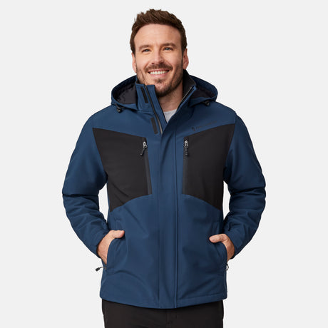 [Joe is 6'0" wearing size M.]  "Men’s Free Country hooded zip-front jacket with black chest panels and deep blue sleeves and body—features dual vertical zippered chest pockets, side hand pockets, full-length zipper closure, and an attached interior snow skirt for added protection against snow and wind. Styled with black pants for a sleek, functional cold-weather look.