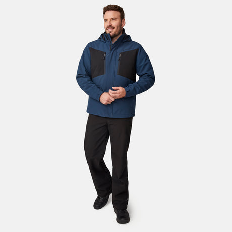 A man wears a blue, water-resistant Men’s Thermo Softshell® Mid Weight Jacket with black chest panels and black pants.
