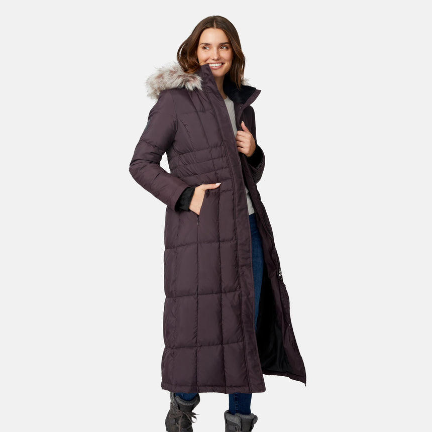 [Jessica is 5'9.5" wearing size S.] Woman wearing Free Country Women's Full Length Splendor Down Jacket in dark brown with a full front zipper opening, lower pockets, calf length, a detachable hood with faux fur trim, and water resistant and wind resistant stretch performance fabric, light grey background. Best women’s jacket for winter weather.