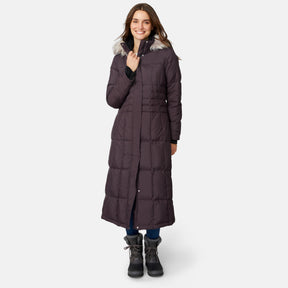 [Jessica is 5'9.5" wearing size S.] Woman wearing Free Country Women's Full Length Splendor Down Jacket in dark brown with a full front zipper opening, lower pockets, calf length, a detachable hood with faux fur trim, and water resistant and wind resistant stretch performance fabric, light grey background. Best women’s jacket for winter weather.
