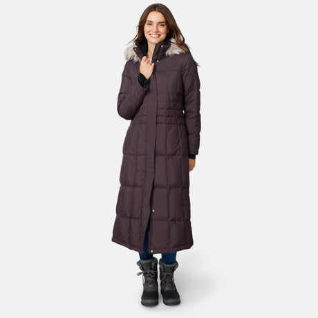 [Jessica is 5'9.5" wearing size S.] Woman wearing Free Country Women's Full Length Splendor Down Jacket in dark brown with a full front zipper opening, lower pockets, calf length, a detachable hood with faux fur trim, and water resistant and wind resistant stretch performance fabric, light grey background. Best women’s jacket for winter weather.