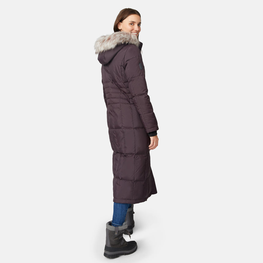 [Jessica is 5'9.5" wearing size S.] Woman wearing Free Country Women's Full Length Splendor Down Jacket in dark brown with a full front zipper opening, lower pockets, calf length, a detachable hood with faux fur trim, and water resistant and wind resistant stretch performance fabric, light grey background. Best women’s jacket for winter weather.