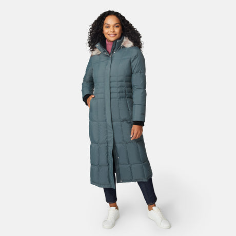 [Angelique is 5'10" wearing size S.] Woman wearing Free Country Women's Full Length Splendor Down Jacket in green with a full front zipper opening, lower pockets, calf length, a detachable hood with faux fur trim, and water resistant and wind resistant stretch performance fabric, light grey background. Best women’s jacket for winter weather.