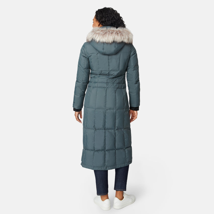 [Angelique is 5'10" wearing size S.] Woman wearing Free Country Women's Full Length Splendor Down Jacket in green with a full front zipper opening, lower pockets, calf length, a detachable hood with faux fur trim, and water resistant and wind resistant stretch performance fabric, light grey background. Best women’s jacket for winter weather.